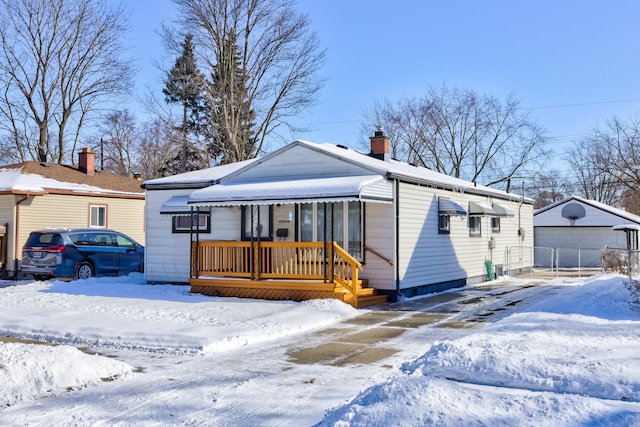 view of front of home featuring a garage, a chimney, and a porch