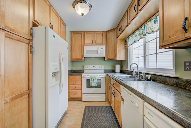 kitchen with white appliances, dark countertops, a sink, and light wood-style flooring