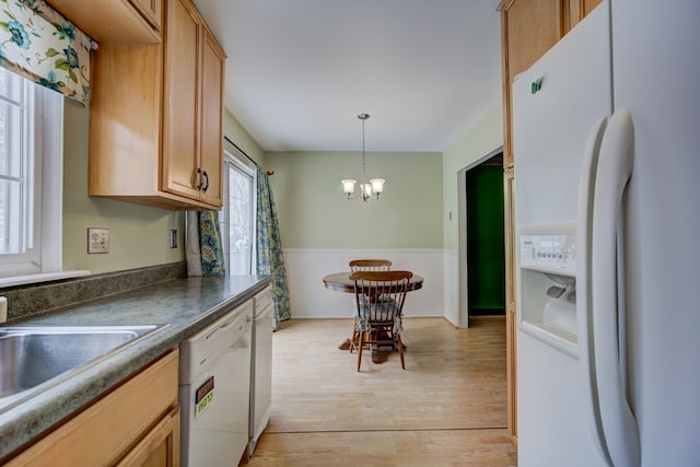 kitchen featuring white appliances, a sink, wainscoting, light wood finished floors, and dark countertops