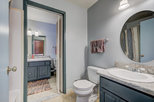 bathroom featuring tile patterned flooring, vanity, and toilet