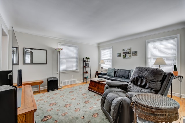 living area featuring visible vents, baseboards, and wood finished floors