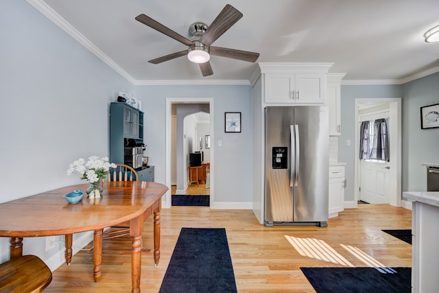 kitchen featuring crown molding, stainless steel appliances, light countertops, white cabinetry, and light wood-type flooring