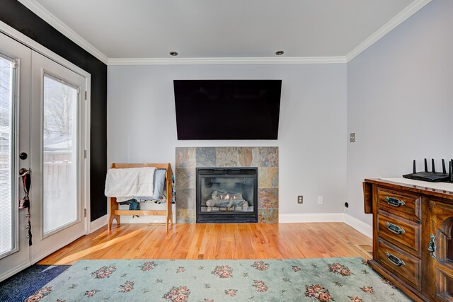 living room featuring ornamental molding, a tile fireplace, french doors, and wood finished floors