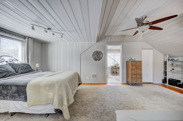 bedroom featuring light wood-type flooring, multiple windows, visible vents, and vaulted ceiling