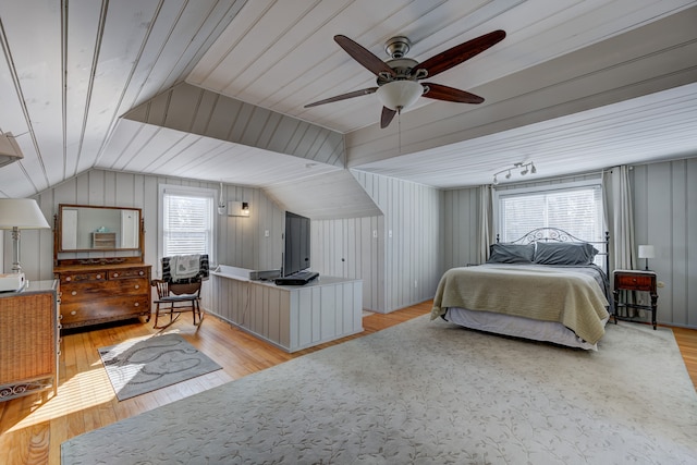 bedroom with vaulted ceiling, light wood finished floors, and a ceiling fan