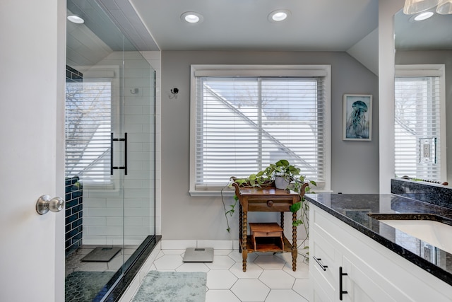 full bath with a stall shower, baseboards, tile patterned flooring, vaulted ceiling, and vanity