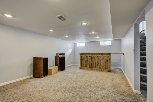 below grade area featuring visible vents, baseboards, carpet, stairs, and recessed lighting