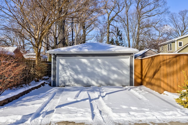 snow covered garage featuring a garage