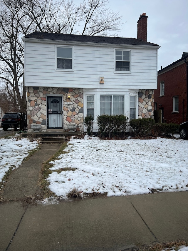 view of front facade featuring stone siding and a chimney