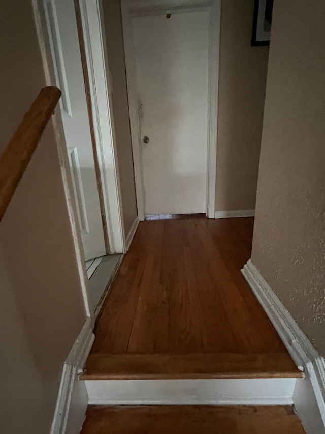 hall with baseboards and wood finished floors