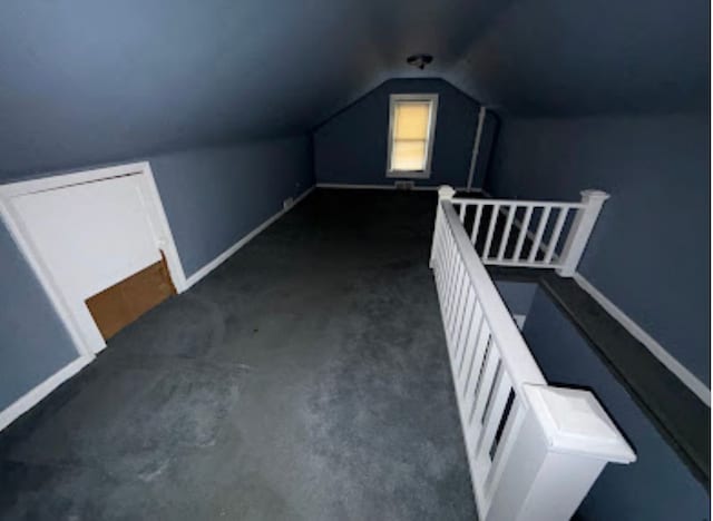 bonus room featuring vaulted ceiling, baseboards, and dark colored carpet