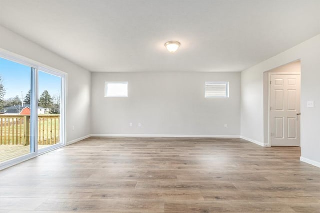 unfurnished room with light wood finished floors and baseboards