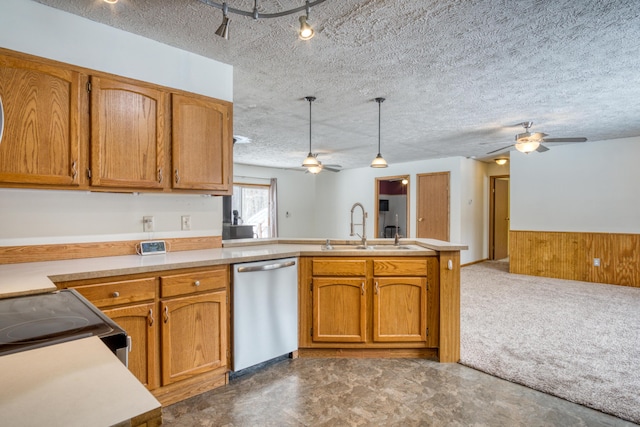 kitchen featuring a peninsula, a sink, light countertops, stainless steel dishwasher, and pendant lighting