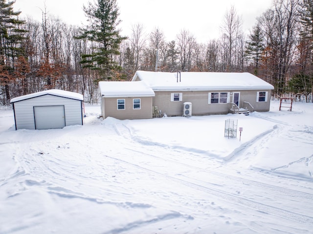 view of front of property featuring entry steps, a detached garage, and an outbuilding