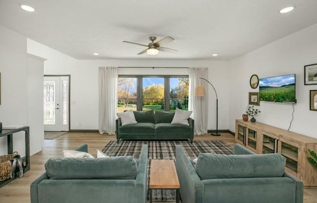 living area with light wood-type flooring, ceiling fan, baseboards, and recessed lighting