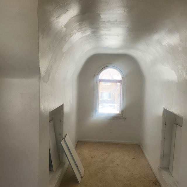 bonus room featuring light carpet, vaulted ceiling, and baseboards