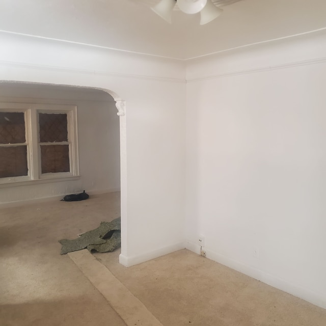spare room featuring arched walkways and ceiling fan