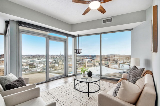 living room with light wood finished floors, plenty of natural light, a view of city, and visible vents