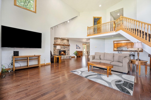 living area featuring stairs, a fireplace, and wood finished floors