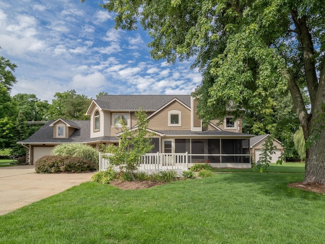 view of front of property with a garage, a sunroom, a front lawn, and concrete driveway