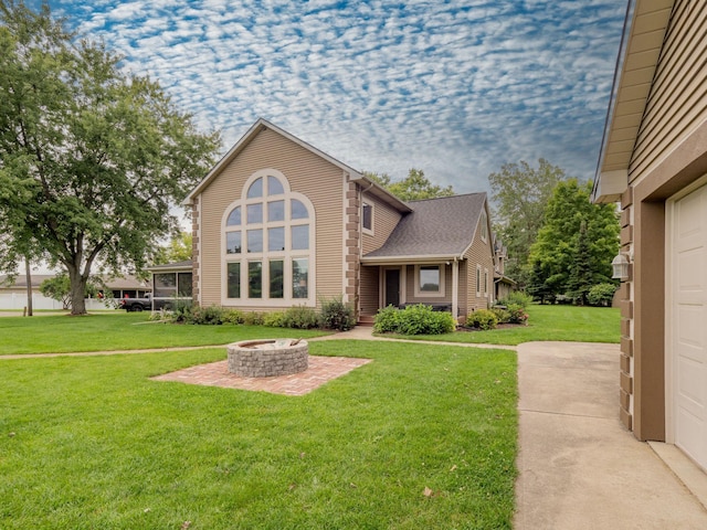 view of front facade with a garage, an outdoor fire pit, and a front yard