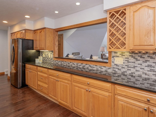 kitchen with dark wood-style flooring, recessed lighting, visible vents, decorative backsplash, and freestanding refrigerator