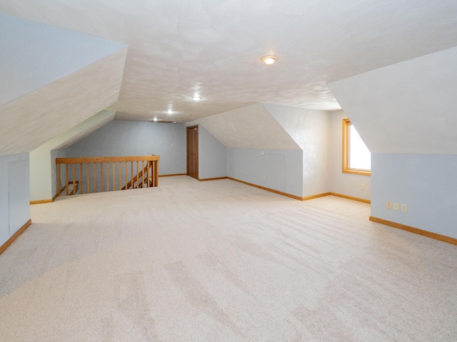 bonus room with vaulted ceiling, carpet flooring, and baseboards