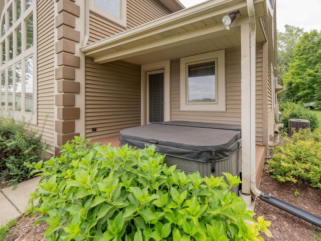 property entrance featuring central AC and a hot tub