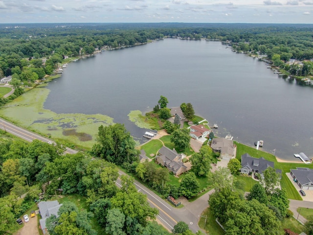 drone / aerial view featuring a water view, a wooded view, and a residential view