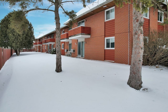 yard layered in snow with fence and a balcony