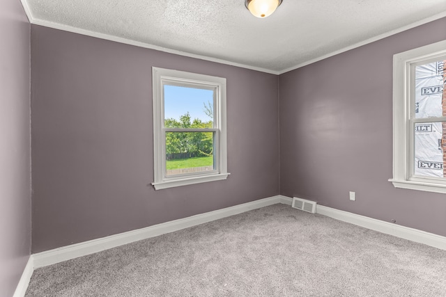 carpeted spare room featuring visible vents, crown molding, a textured ceiling, and baseboards