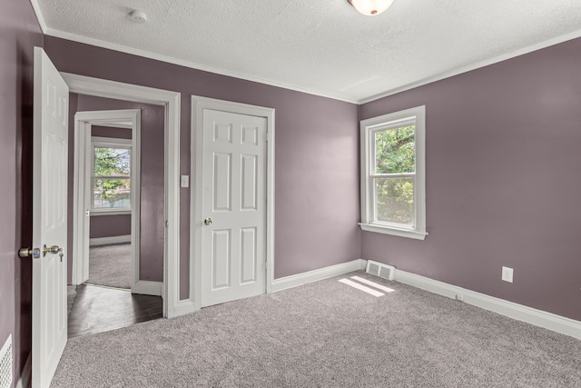 unfurnished room featuring baseboards, carpet floors, visible vents, and a healthy amount of sunlight