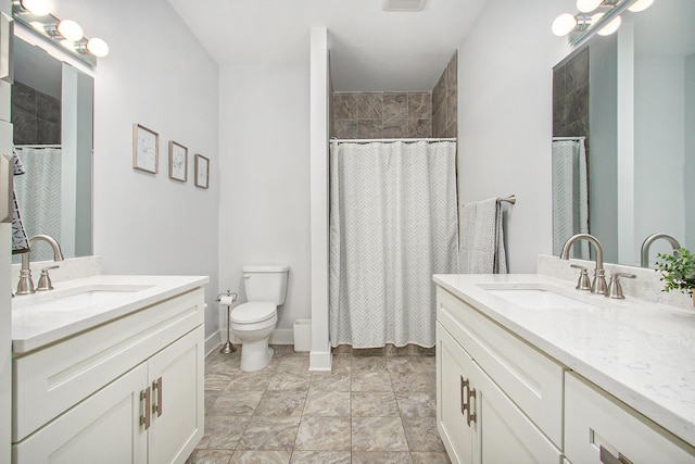 bathroom featuring two vanities, a sink, and toilet