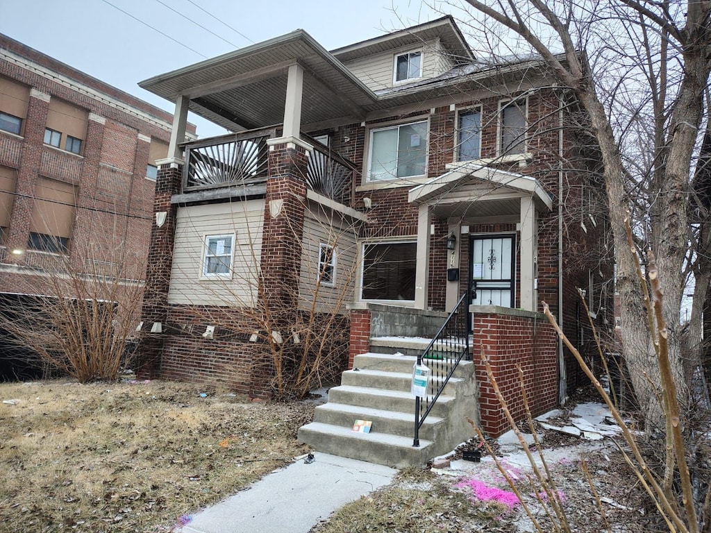 american foursquare style home with brick siding