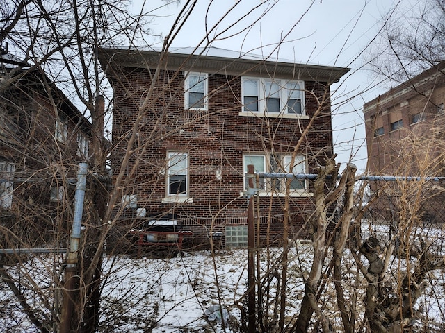 snow covered house with brick siding