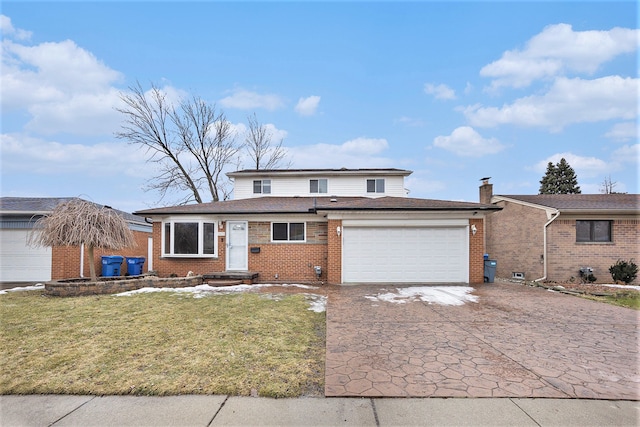 view of front of house with a front lawn, decorative driveway, an attached garage, and brick siding