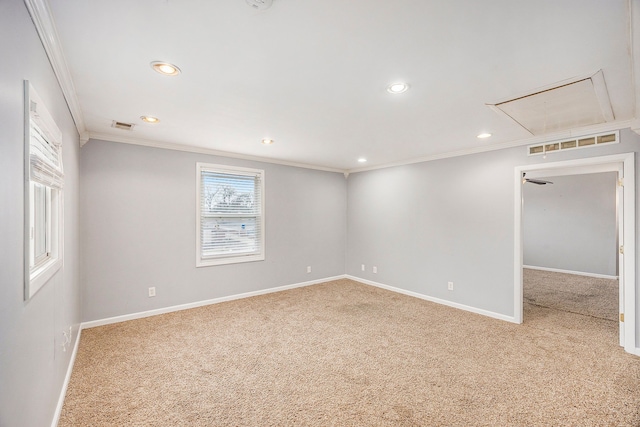 carpeted empty room with recessed lighting, visible vents, baseboards, ornamental molding, and attic access