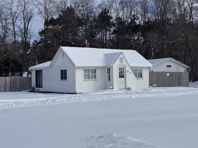 ranch-style house featuring fence and a chimney