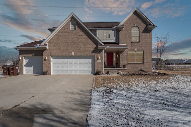 traditional home featuring a garage, brick siding, and concrete driveway