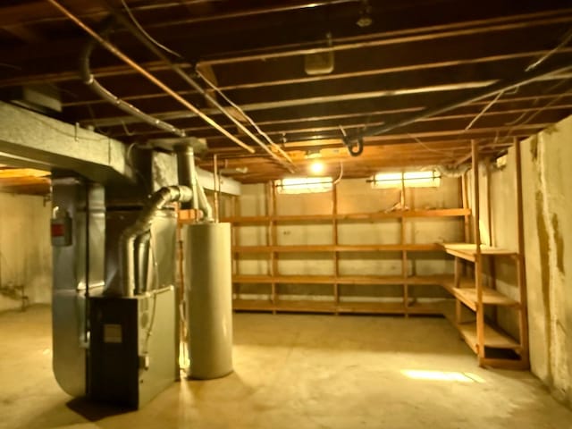 unfinished below grade area with heating unit and water heater