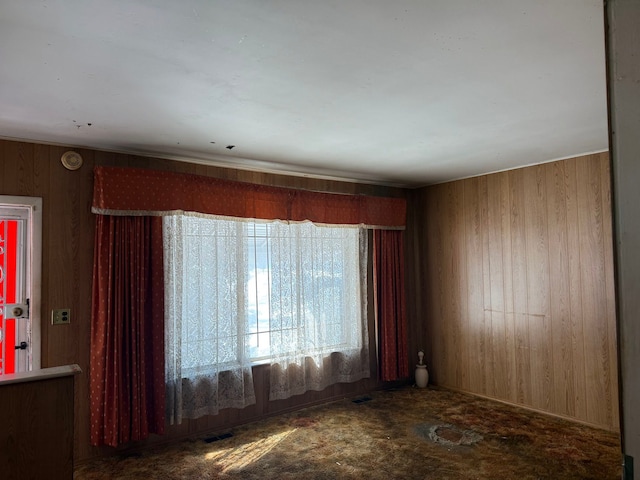 unfurnished room featuring visible vents and wooden walls