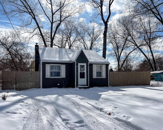 view of front of home featuring a chimney and fence