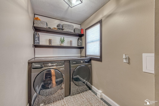 laundry room with laundry area, baseboards, a textured wall, a textured ceiling, and washer and dryer