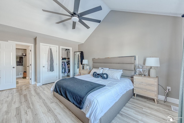 bedroom with light wood finished floors, a closet, a walk in closet, and baseboards