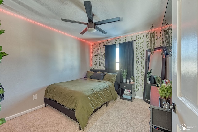 bedroom with light colored carpet, ceiling fan, a textured ceiling, and baseboards