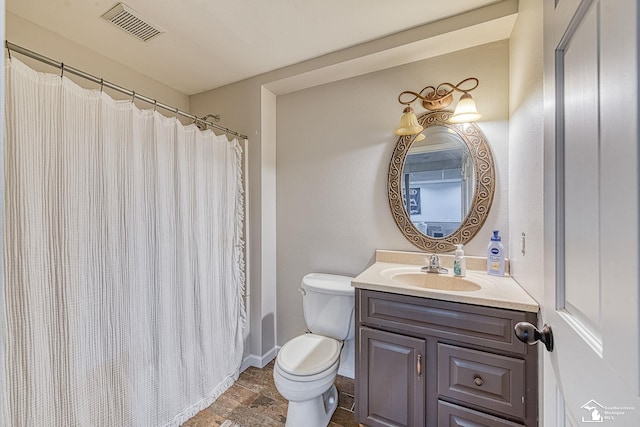 bathroom featuring visible vents, baseboards, toilet, stone finish flooring, and vanity