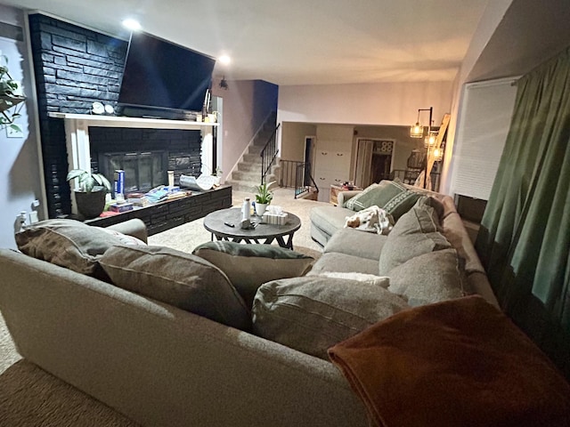 carpeted living area featuring stairway and a glass covered fireplace