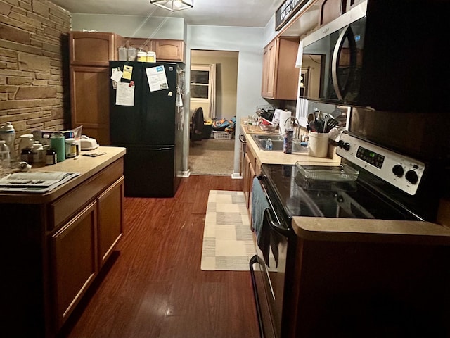 kitchen with appliances with stainless steel finishes, light countertops, dark wood-type flooring, and a sink