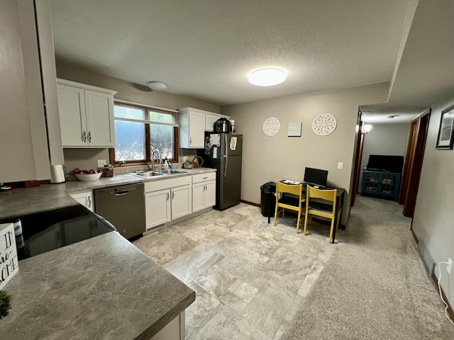 kitchen with white cabinets, dishwasher, freestanding refrigerator, a textured ceiling, and a sink