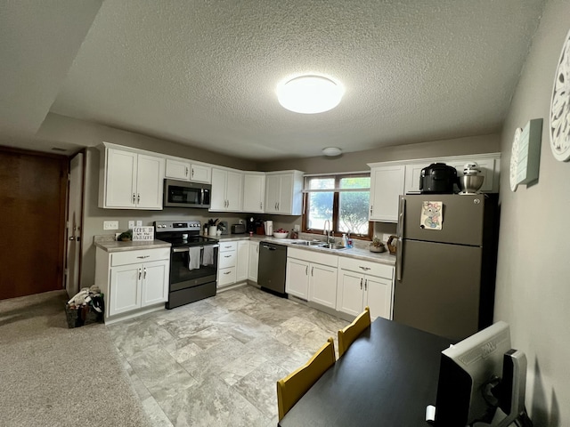 kitchen featuring a sink, white cabinetry, stainless steel appliances, and light countertops